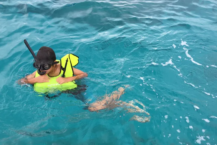 a young girl riding a wave on a surfboard in the water